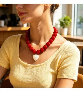 Vue détaillée d'un collier de perles rouges de mode pour femmes avec un pendentif cœur.
