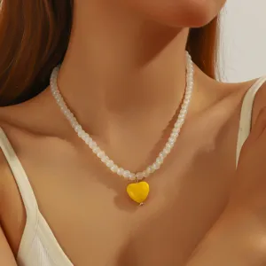Collier de perles minimaliste pour femmes avec un pendentif coeur jaune pour style.