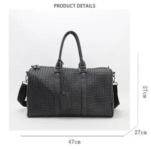 Close-up detail of black woven leather travel duffel bag showing intricate craftsmanship and size.