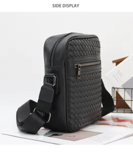 Detailed view of the black woven leather shoulder bag showcasing texture and zipper pocket.