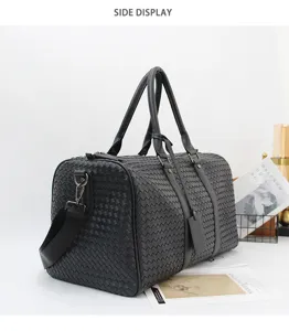 Detailed side view of black woven leather travel duffel bag with adjustable shoulder strap