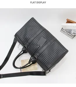 Detailed view of black woven leather travel duffel bag with shoulder strap and premium texture.