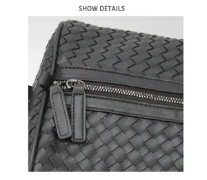 Black woven leather travel bag detail view, premium business luggage shoulder duffel bag.