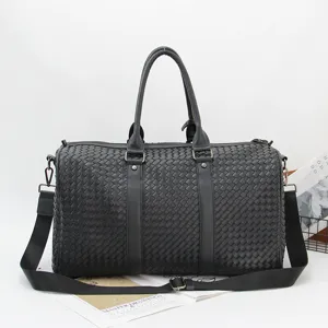Black woven leather travel duffel bag for men, large capacity business luggage and shoulder bag.