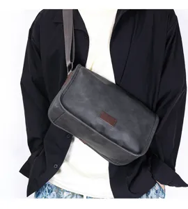 Detail view of the dark grey men's crossbody messenger bag, highlighting texture and strap.
