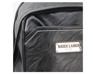 Black faux leather backpack detail close up showing texture and brand logo metal plate.