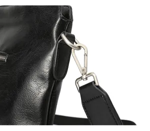 Primo piano sugli accessori della tracolla e sui dettagli della borsa da lavoro in pelle.