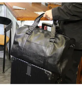 Black leather travel duffel bag business weekender bag close up detail view shot.