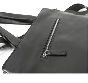 Vista dettagliata della borsa in pelle nera con tasca con zip e comodi manici.