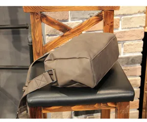 Detail shot of men's casual crossbody messenger bag showing shoulder strap and texture.