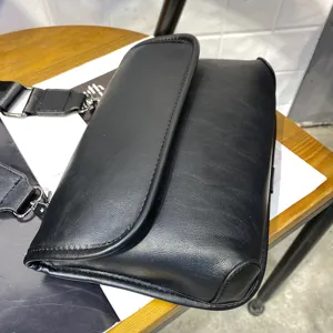 Black mens casual leather crossbody bag with adjustable strap for daily outdoor commuting.
