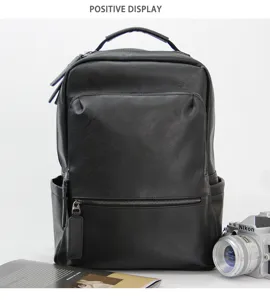 Close-up detail of black leather backpack in studio setting with camera prop, high texture.