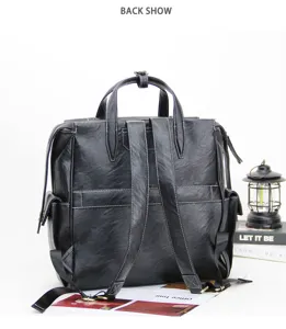 Detailed view of the black leather backpack, showcasing the back design, straps and texture.
