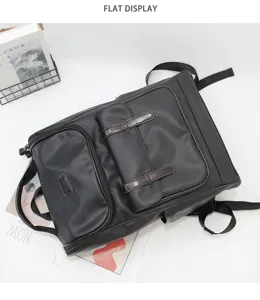 Detail view of black PU leather vintage backpack with brown buckles, flat lay style.