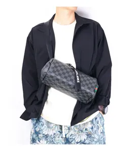 Detailed view of a trendy men's checkered cylinder crossbody bag with zipper pull and strap.