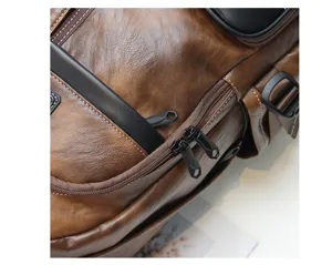 Vintage brown leather backpack detail view with black zippers, durable stitching and compartments.