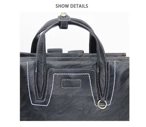 Black leather backpack detail featuring durable top handles, contrast white stitching.
