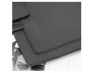 Close-up detail of black leather laptop sleeve showing fine stitching and premium texture.