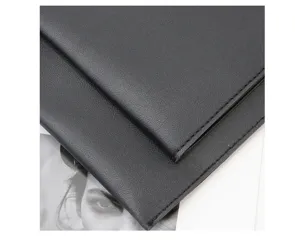 Black leather laptop sleeve detail showing fine stitching and multi-layer slim protective design.