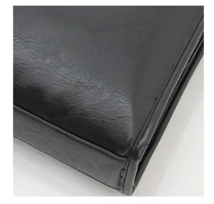 Vista dettagliata dell'angolo di una borsa da lavoro in pelle nera con cuciture fini.