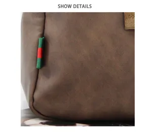 Close-up detail of the brown leather shoulder bag showing the signature striped loop and texture.