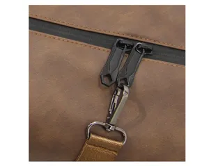 Close-up detail of brown soft leather bag with waterproof zipper, metal hardware and strap.