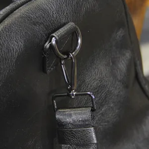 Black leather travel duffel bag metal hardware shoulder strap detail for business trip
