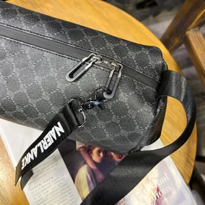 Detailed view of men's dark grey patterned shoulder bag strap and metal zipper hardware.