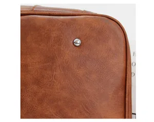 Vue détaillée du sac de voyage vintage marron pour homme avec texture cuir et pied en métal.