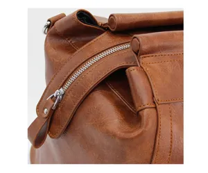 Gros plan sur la fermeture éclair d'un sac de voyage en similicuir marron au design géométrique.