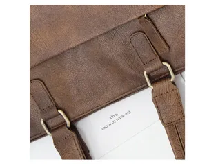 Vista detallada de maletín de negocio retro marrón para hombre con textura, correas y metal.