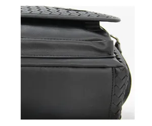 Detailed view of black leather woven messenger bag showing premium texture and craftsmanship.