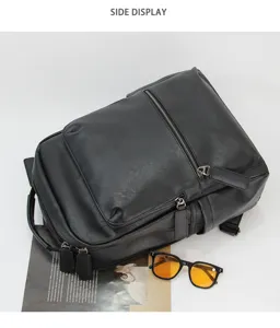 Detailed top view of a black leather backpack with zip pockets, styled with sunglasses.
