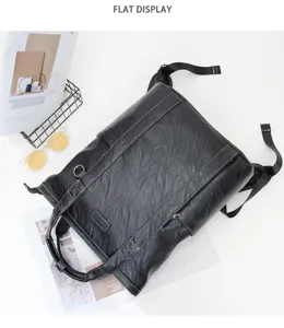 Vue à plat détaillée d'un sac à dos multifonctionnel en cuir synthétique noir avec surpiqûres.