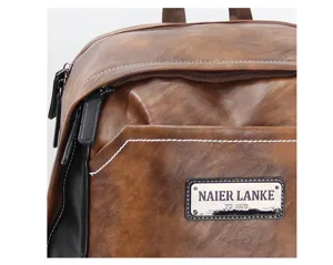 Vintage brown backpack detail view close up leather rucksack with front pocket and metal tag label