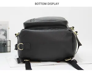 Bottom detail view of black leather-like men backpack with metal D-rings and sturdy straps.