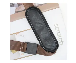 Close up detail view of durable brown shoulder strap with black leather pad and adjustable buckle.