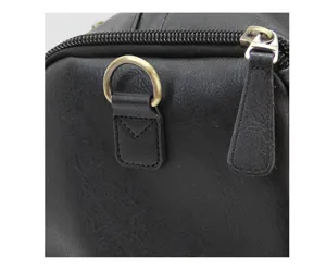 Black leather bag detail close-up showing metal zipper and D-ring buckle hardware design.