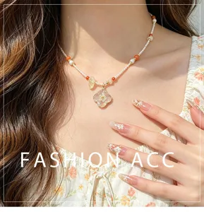 Détail de collier claviculaire de perles avec pendentif fleur séchée en résine et perles.