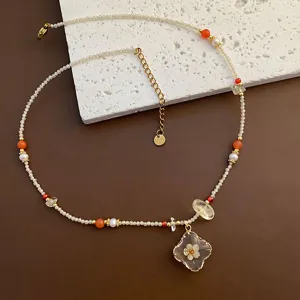 Collier de perles avec pendentif en résine de fleurs séchées et pierre naturelle simple chic.