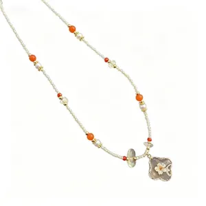 Collier tendance en perles avec pendentif trèfle, design élégant pour un look quotidien.