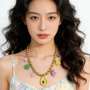 Close-up detail of trendy gold-tone bead necklace featuring colorful enamel fruit and flower charms.