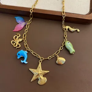 Detailed closeup of a gold-toned ocean-themed charm necklace featuring marine animal pendants.