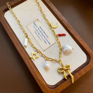 Detail shot of the titanium steel charm necklace featuring cute bow, pearl and star pendants.