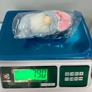 Λεπτομέρεια λούτρινης κούκλας πασχαλινού νάνου με ένδειξη βάρους σε διαφανή σακούλα.