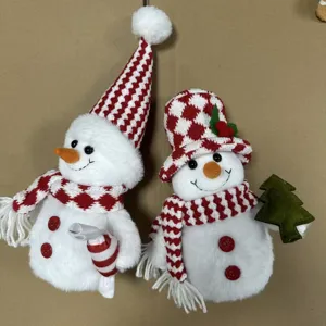 Gros plan de poupées en peluche de bonhomme de neige de Noël avec bonnets tricotés.