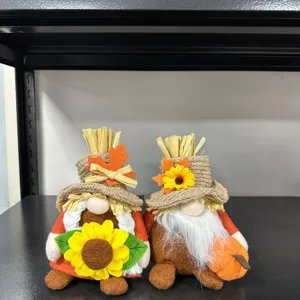 Nahaufnahme Detailansicht von Herbst Ernte Zwerg Plüschpuppen mit Strohhüten und Sonnenblumen.