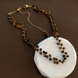 Detailansicht der Tigerauge Perlenkette mit facettierten Edelsteinperlen und goldener Kette.