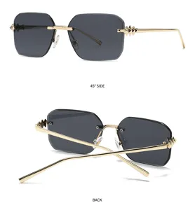 Lunettes de soleil carrées sans monture avec branches dorées à rivets et verres gris.