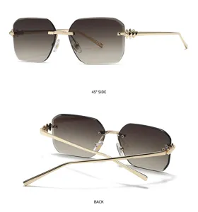Lunettes de soleil carrées sans monture avec verres dégradés et détails de clous dorés.